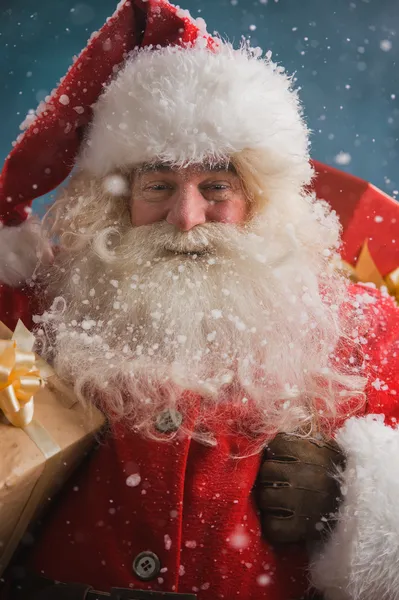 Claus buitenshuis in sneeuwval uitvoering geschenken — Stockfoto