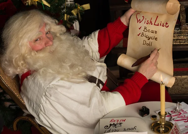 Weihnachtsmann schreibt auf alte Papierrolle — Stockfoto