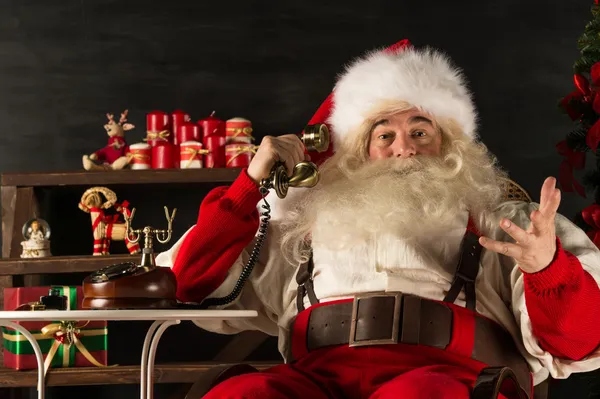 Weihnachtsmann telefoniert zu Hause — Stockfoto