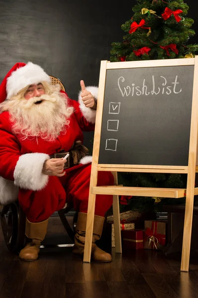 Santa Claus sentado cerca de pizarra — Foto de Stock