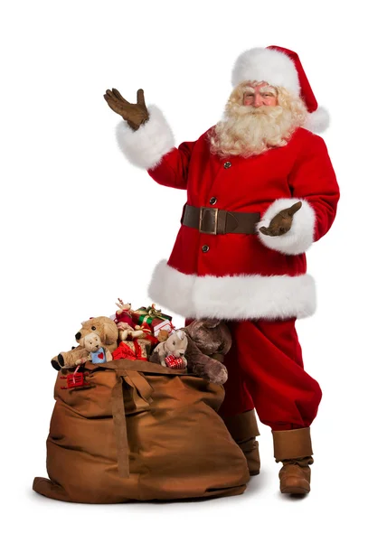 Babbo Natale posa vicino a una borsa piena di regali — Foto Stock