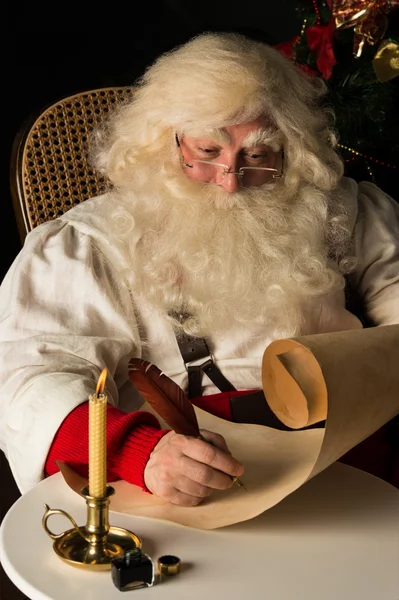 Babbo Natale seduto a casa e scrivere per fare la lista — Foto Stock