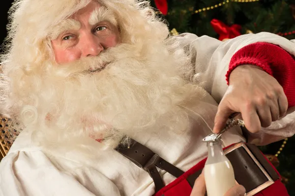 Weihnachtsmann trinkt Milch aus Glasflasche — Stockfoto