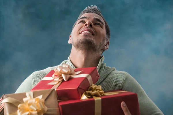 Le jeune homme porte beaucoup de cadeaux — Photo