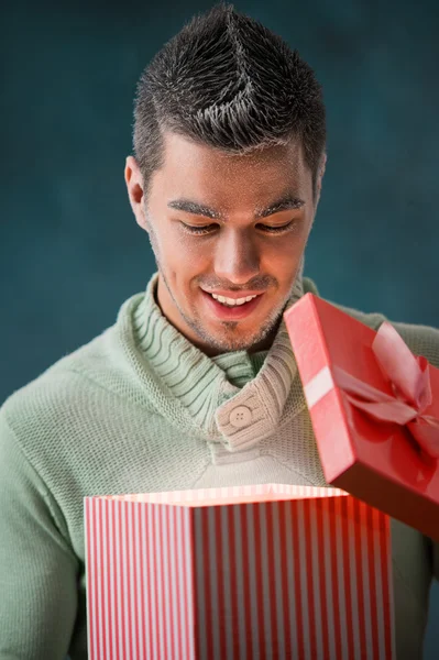 Взволнованный человек открывает большую подарочную коробку — стоковое фото