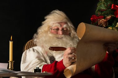 Noel Baba evde oturan ve Yapılacaklar listesi yazma