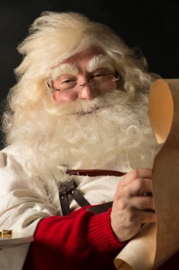 Noel Baba evde oturan ve Yapılacaklar listesi yazma