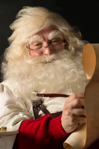 Санта-Клаус сидит дома и пишет список дел — стоковое фото
