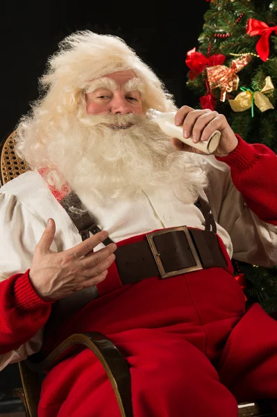 Santa claus konzumní mléko ze skleněné láhve — Stock fotografie