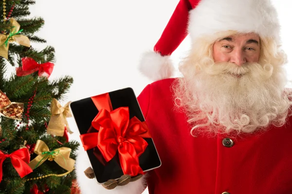 Santa claus håller gåva tablet PC — Stockfoto