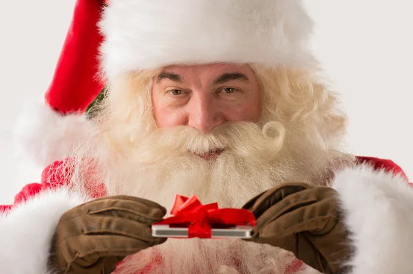 Papai Noel segurando dispositivo de presente em suas mãos — Fotografia de Stock