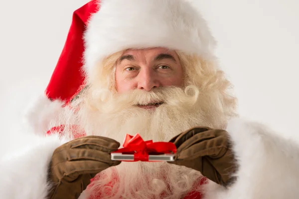 Santa claus bedrijf geschenk apparaat in zijn handen — Stockfoto