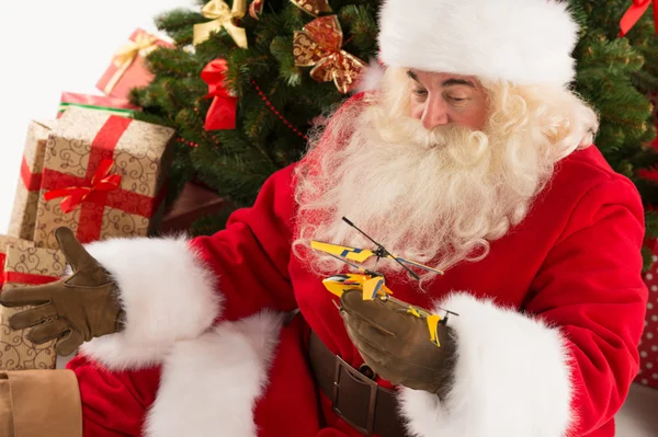 Santa claus houden geschenk helikopter speelgoed — Stockfoto