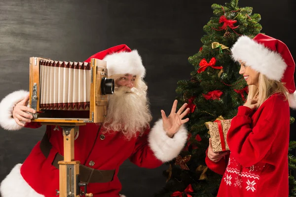 Foto de Papai Noel com sua esposa tirando fotos — Fotografia de Stock