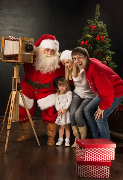 Santa claus biorąc obraz rodziny pełne aparatem stare drewniane — Zdjęcie stockowe