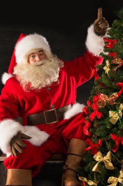 Noel Baba, karanlık odada Noel ağacı süsleme