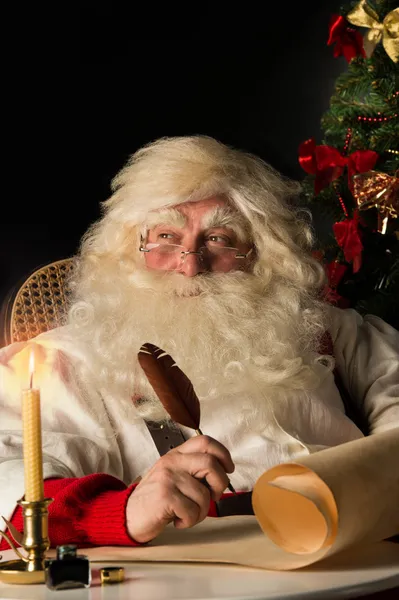 Papá Noel sentado en casa y escribiendo una carta —  Fotos de Stock