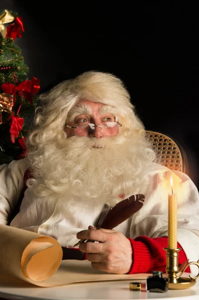 Papá Noel sentado en casa y escribiendo una carta — Foto de Stock