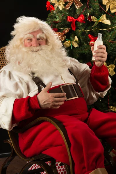 Happy Santa Claus drinking milk from glass bottle — Stock Photo, Image