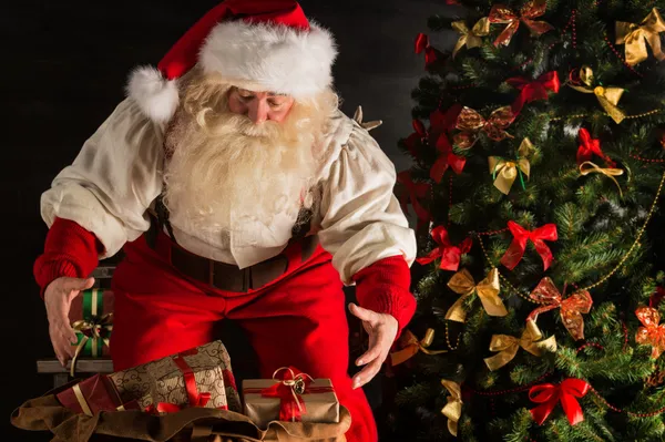 Papai Noel abrindo seu saco e levando presentes — Fotografia de Stock