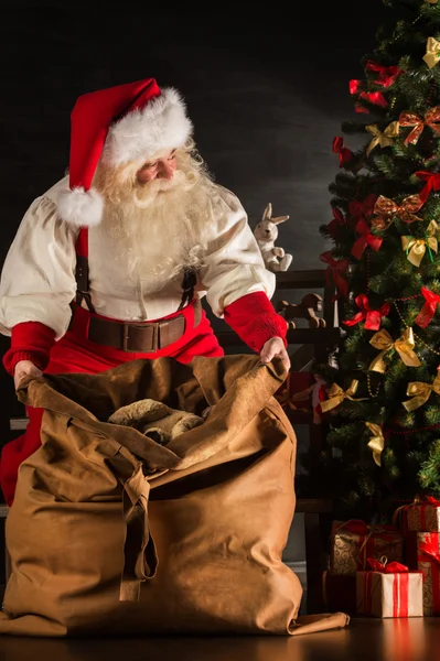 Papai Noel abrindo seu saco e levando presentes — Fotografia de Stock