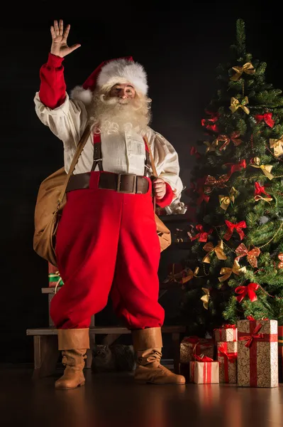 Real Santa Claus llevando una gran bolsa llena de regalos — Foto de Stock