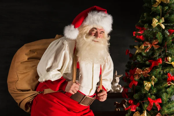 Real Santa Claus llevando una gran bolsa llena de regalos — Foto de Stock