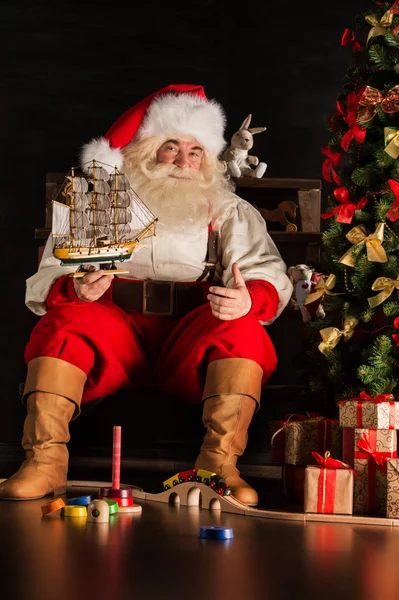 Papá Noel en casa jugando con juguetes nuevos —  Fotos de Stock