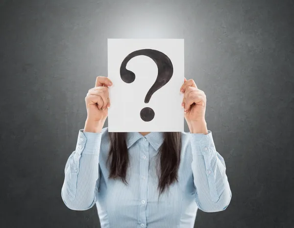 Young woman holding interrogation symbol in front of her face — Stock Photo, Image