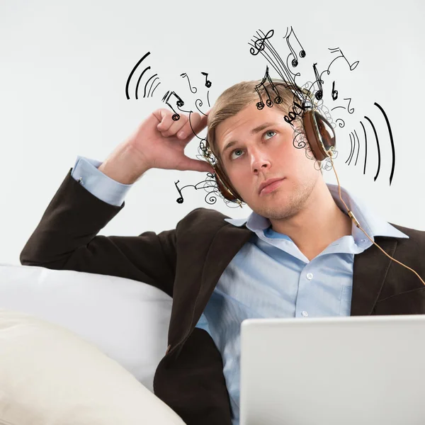 Young business man listening to music and working in his wake — Stock Photo, Image