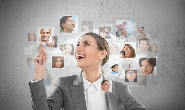 Young successful business woman looking at people portraits. — Stock Photo, Image