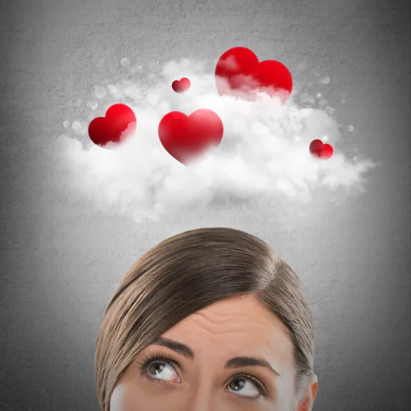Red hearts flying in cloud overhead of beautiful dreamy woman. — Stock Photo, Image