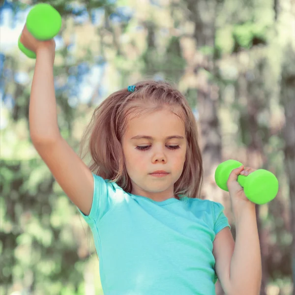 Boldog kislány emelő súlyzók a szabadban park — Stock Fotó