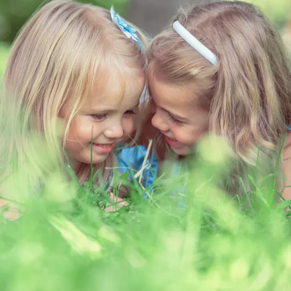 Happy children relaxing on grass in summer park Stock Image