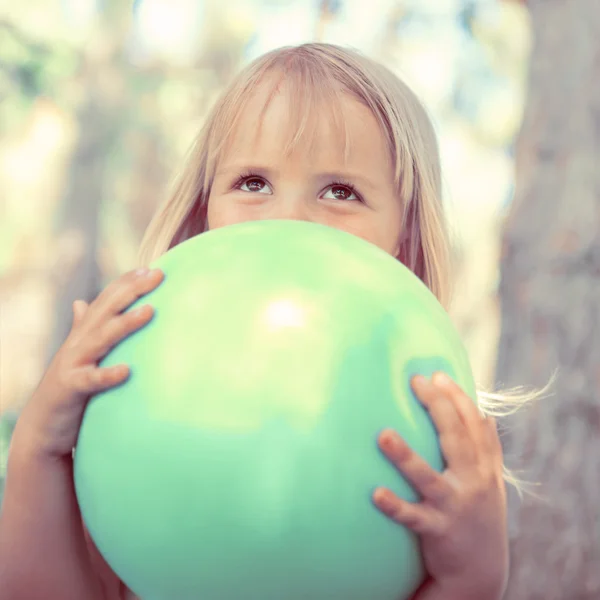 Liten flicka leker med bollen i parken — Stockfoto