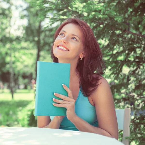 Mulher adulta positiva ler livro ao ar livre — Fotografia de Stock