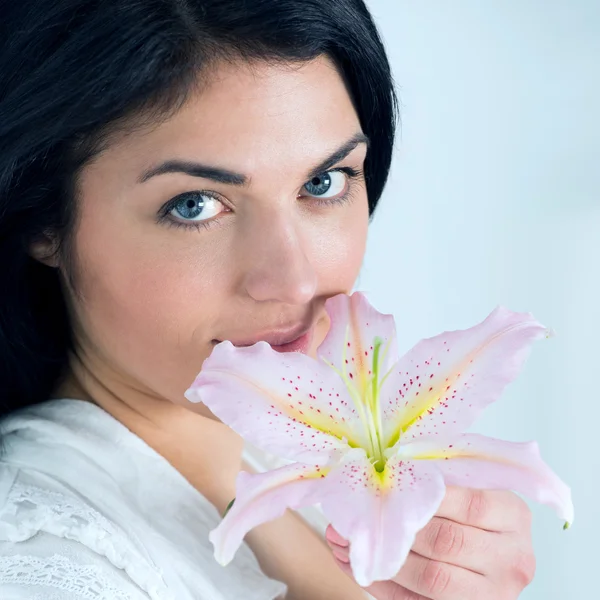 Attractive young woman holding a lily flower — Stock Photo, Image