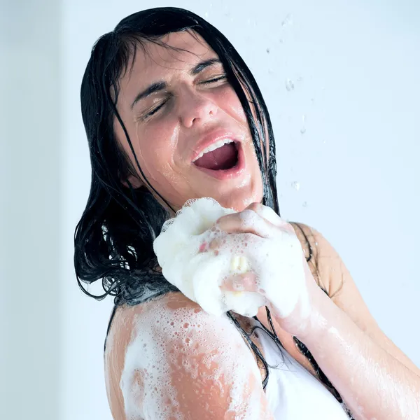 Jovem mulher lavando o corpo com gel de chuveiro — Fotografia de Stock