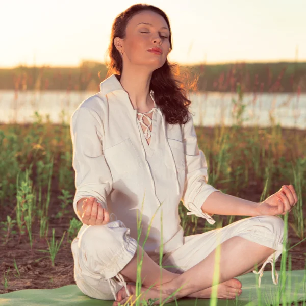 Güzel bir genç kadın yoga yaparken — Stok fotoğraf