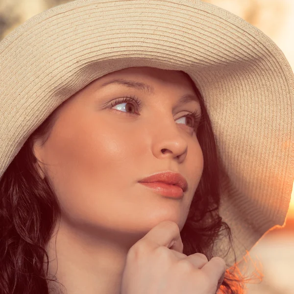Young and beautiful woman wearing a hat in sunset light Stock Picture