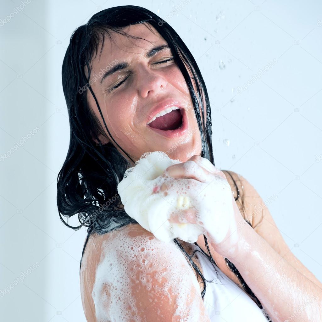 Young woman washing body with shower gel