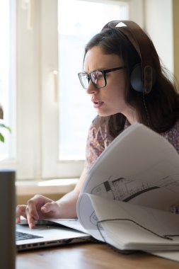 Kadın evde çalışıyor.