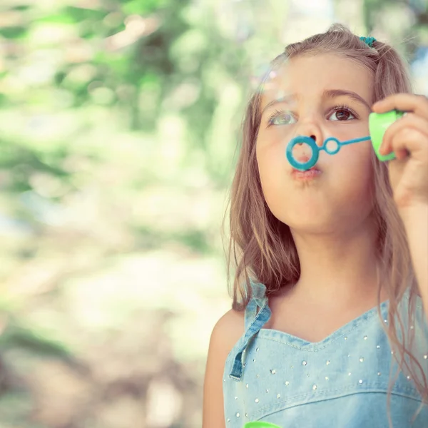 Little girl blowing soap bubbles — Stock Photo, Image