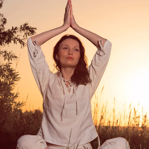 Mujer yoga durante la puesta del sol — Foto de Stock