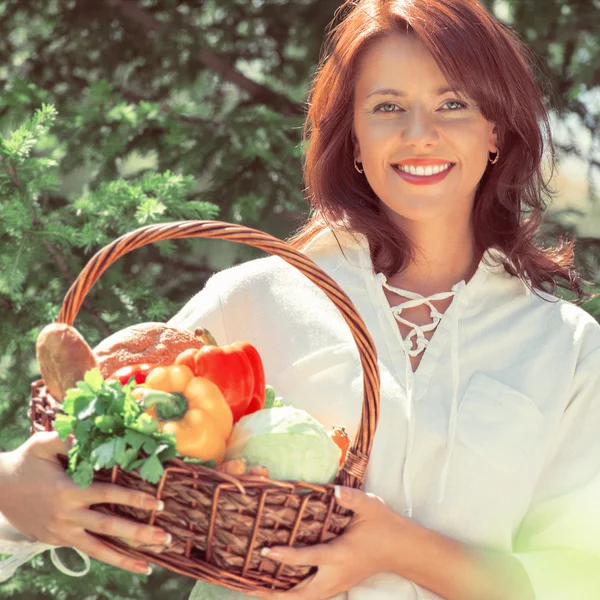 Woman holding basket of vegetables — Stock Photo, Image