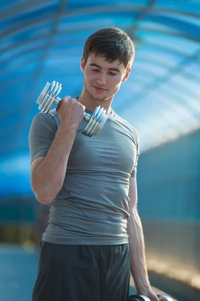 Athletischer Mann mit Hanteln — Stockfoto