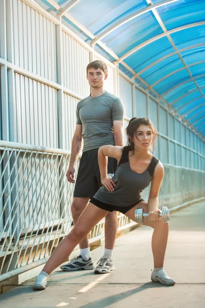 Athletic couple pumping up muscles — Stock Photo, Image