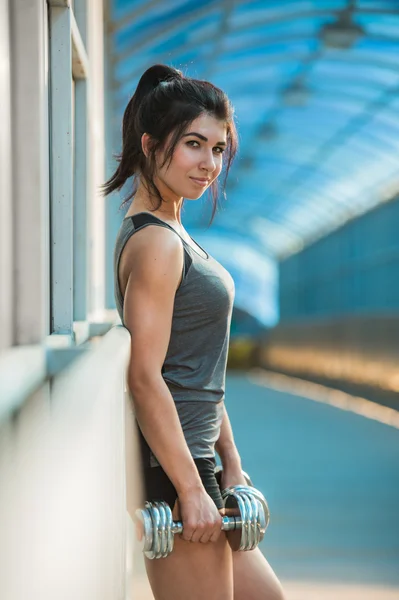 Athletische Frau, die Muskeln aufpumpt — Stockfoto