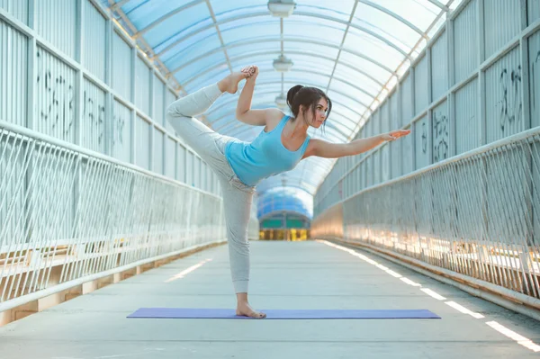Женщина практикует йогу на мосту — стоковое фото