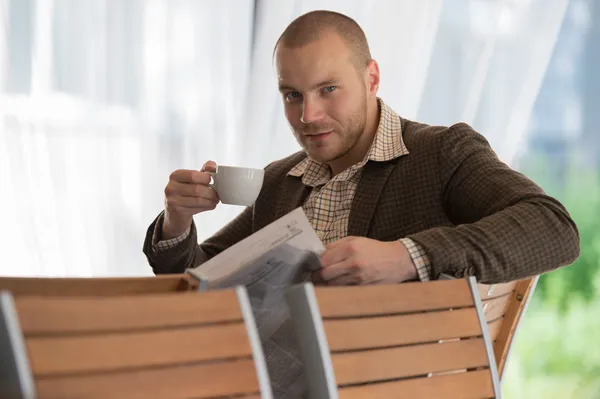 Empresario leyendo periódico en cafetería — Foto de Stock